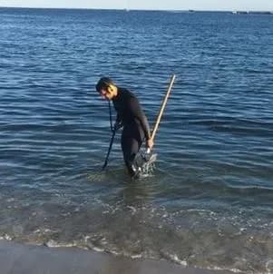 Keith searching waist-deep water at Eastern Point Beach