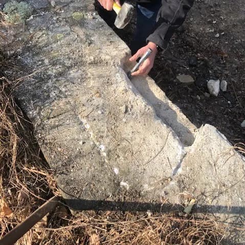 Chipping the stone wall to reach the hidden chamber